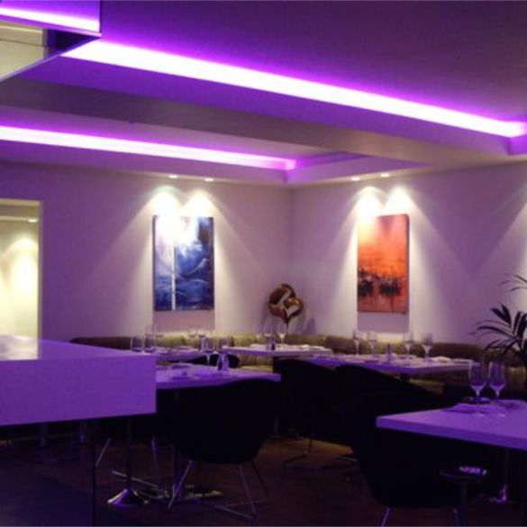 Cove and ceiling in restaurant illuminated by purple coloured LED linear strip lighting